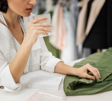 créatrice de mode, vêtements neutres et stylés, dans des tons beiges ou verts, capturée en lumière naturelle pour évoquer la simplicité et l’authenticité de la mode durable