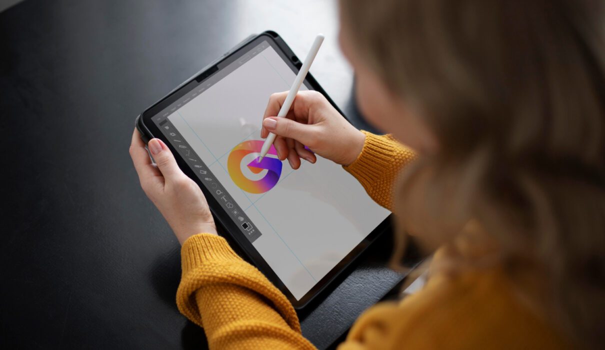une jeune artiste en train de créer sur une tablette graphique ou dans un environnement immersif, avec une projection ou une œuvre digitale colorée en arrière-plan