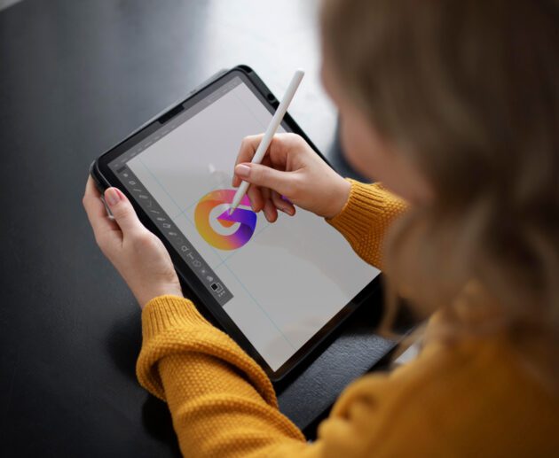 une jeune artiste en train de créer sur une tablette graphique ou dans un environnement immersif, avec une projection ou une œuvre digitale colorée en arrière-plan