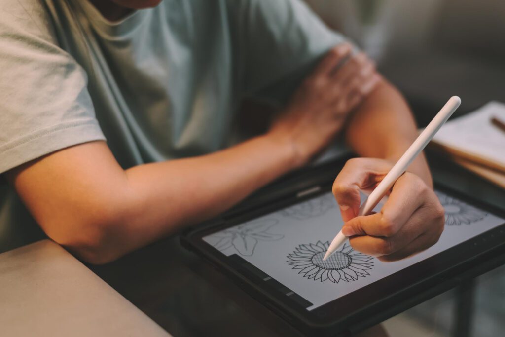 jeune homme graphiste travaillant la nuit à l'aide d'une tablette pour dessiner des travaux d'art