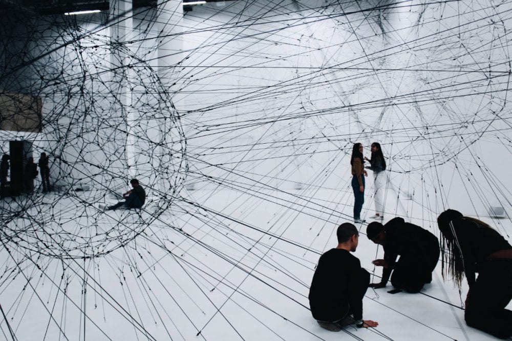 groupe d’artistes et créateurs autour d’une installation immersive, mélangeant écrans, sculptures et dessins, avec des interactions visibles entre participants et technologies numériques