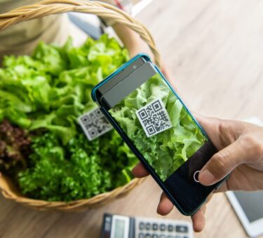panier gastronomique haut de gamme avec un QR code flottant à côté, entourée d’icônes numériques symbolisant blockchain, traçabilité et provenance, avec un éclairage moderne et immersif